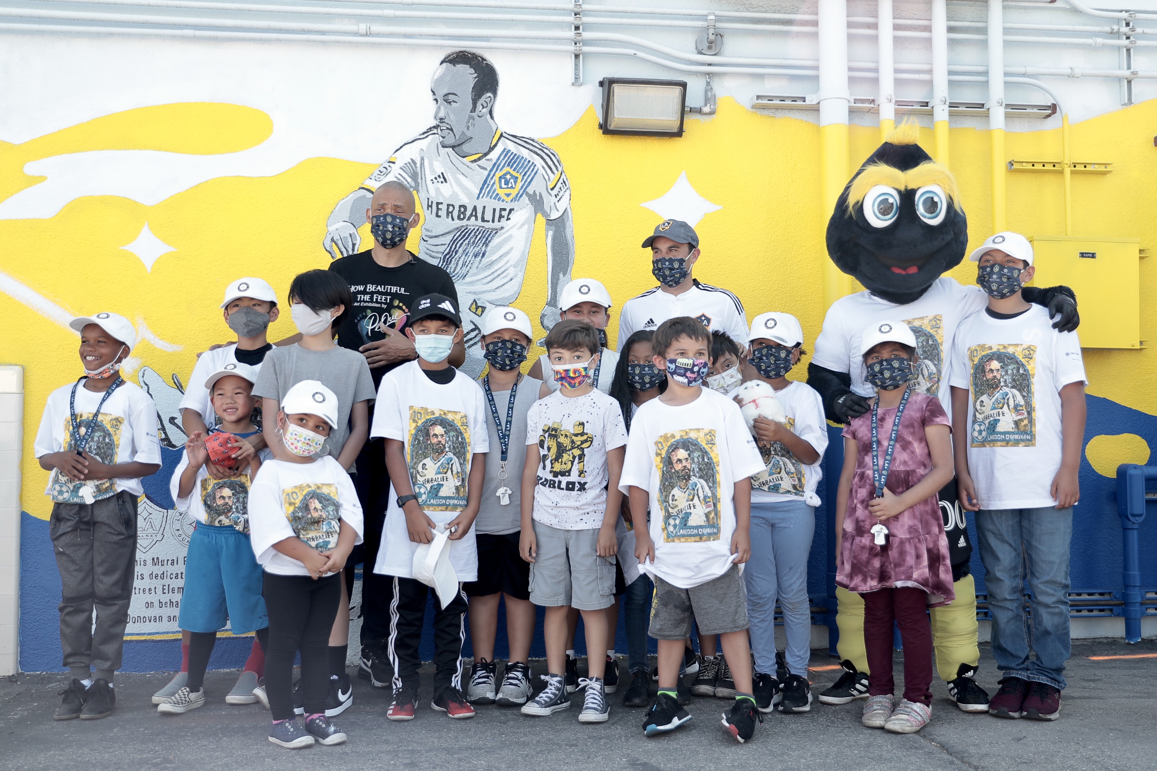 Landon Donovan gathers with a group of children in front of his mural at a local elementary school in Carson, CA. 