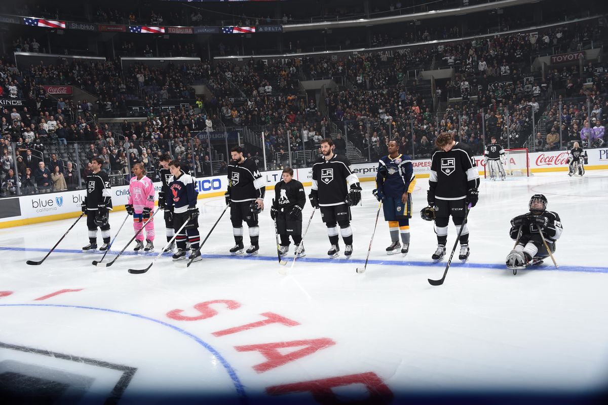 LA Kings players are joined on the ice by representatives from several teams, including the Hawthorne Force, Power Project, LA Kings Sled Hockey, LA Lions, California Condors and SNAP Flyers for the National Anthem in celebration of Hockey Is For Everyone Night at STAPLES Center on February 22, 2018.