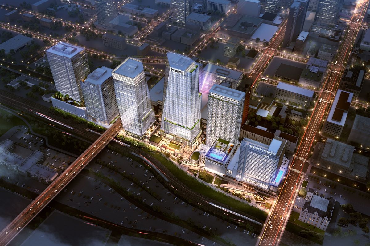 A rendering of Nashville Yards shows glimmering buildings illuminated by lights from an aerial shot. 