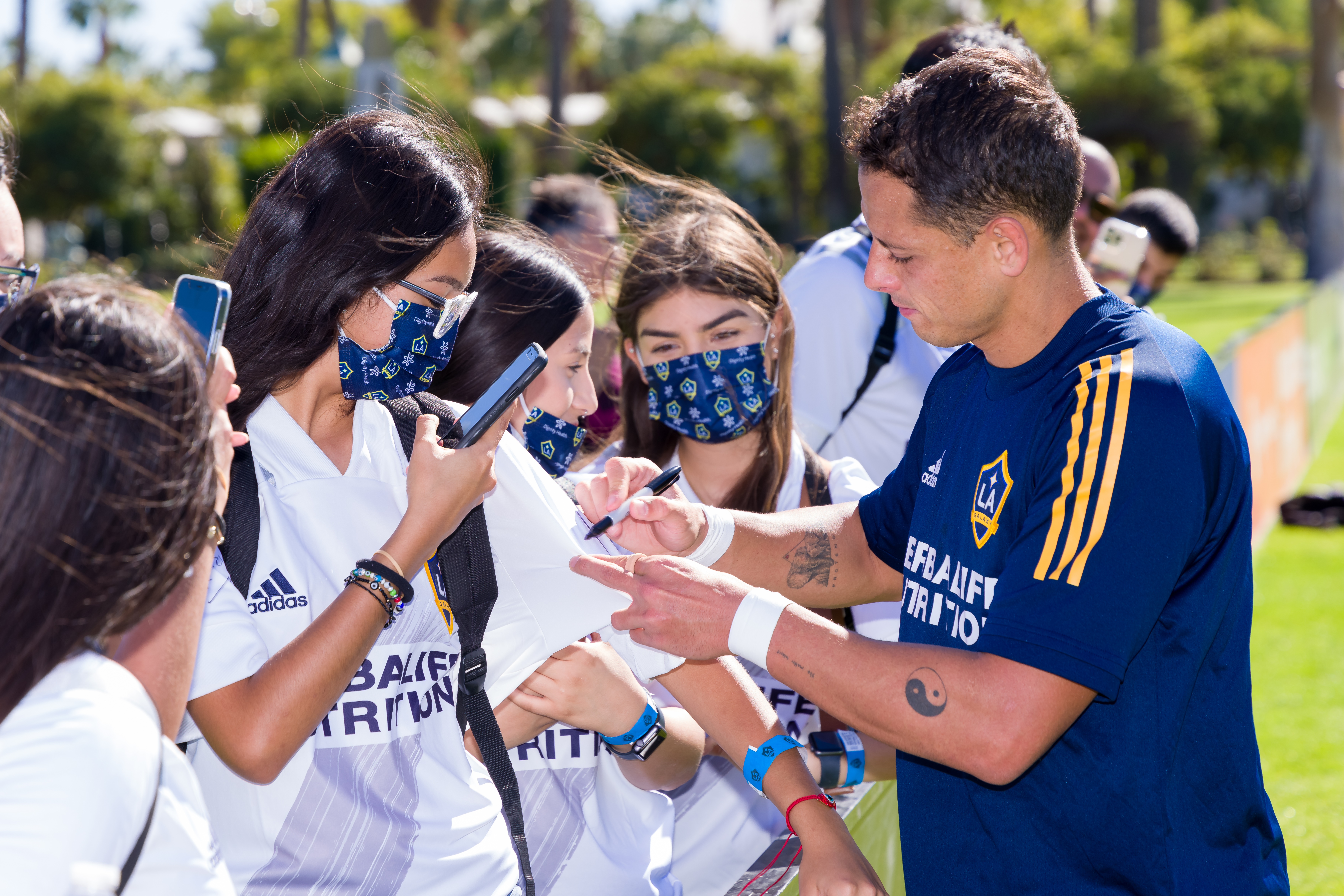 Chicharito signs autographs for students watching a scrimmage at the LA Galaxy Coachella Valley Invitational. 
