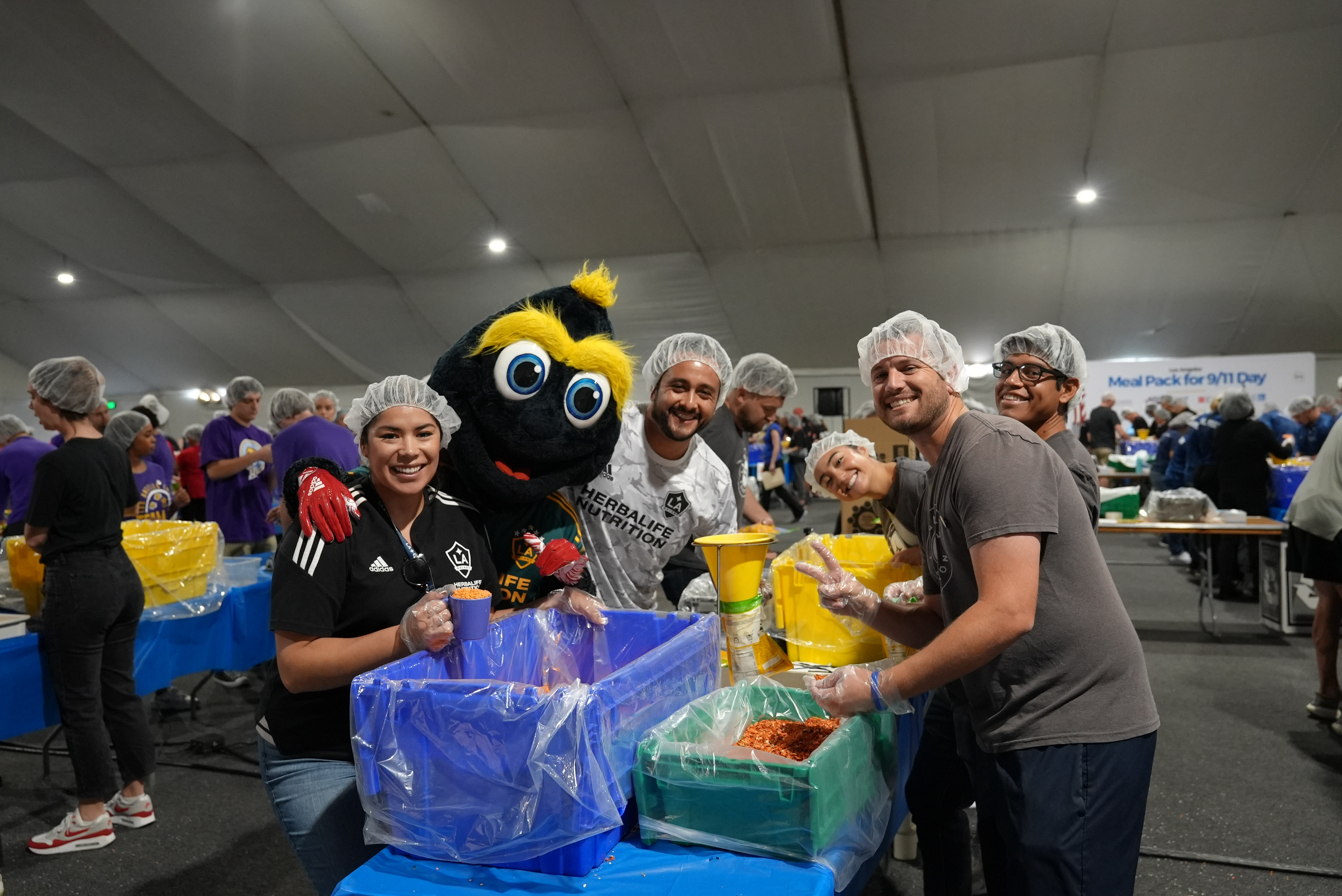 LA Galaxy's Cozmo poses with volunteers from the LA Galaxy