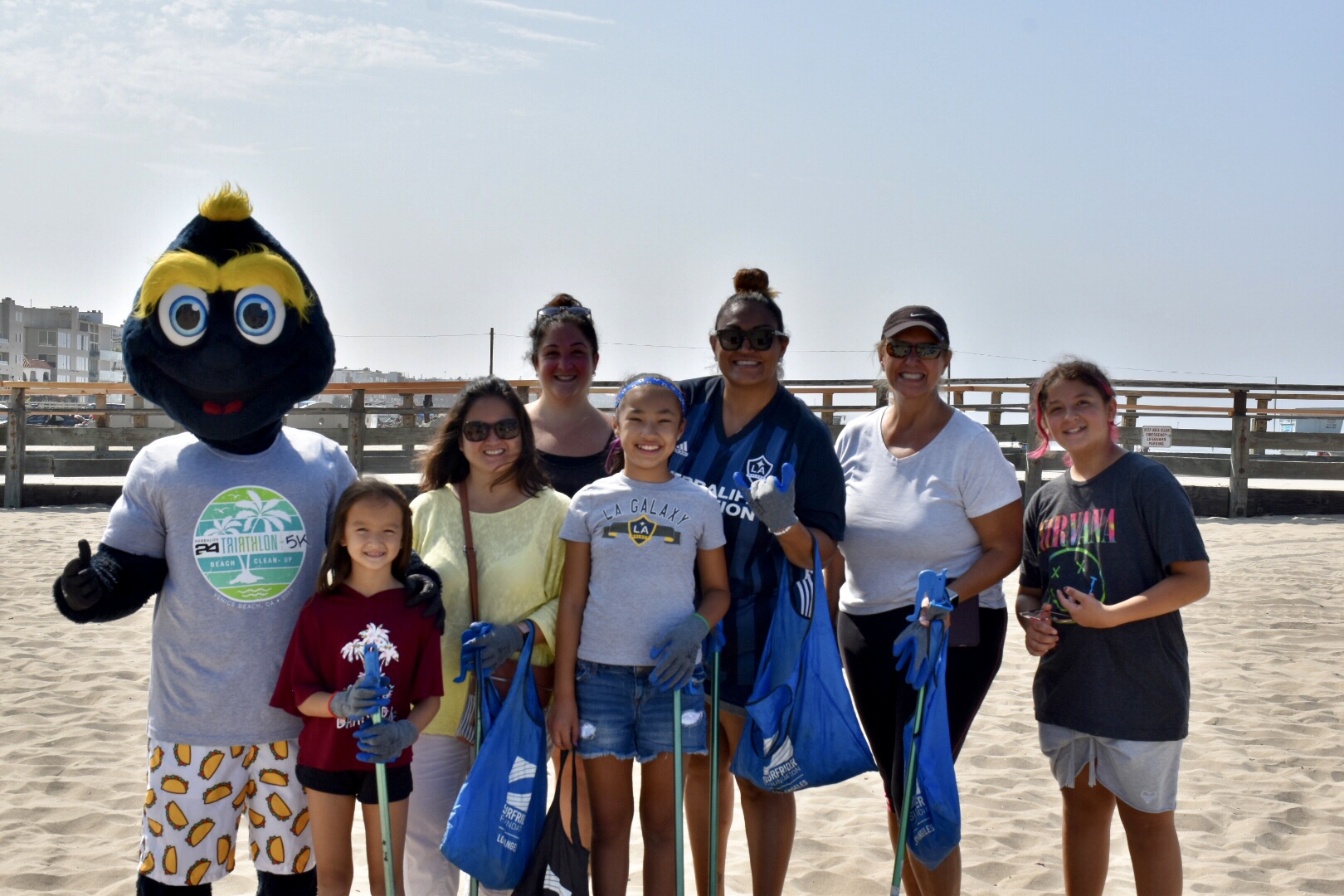 LA Galaxy mascot Cozmo poses with families during a beach cleanup at Venice Beach