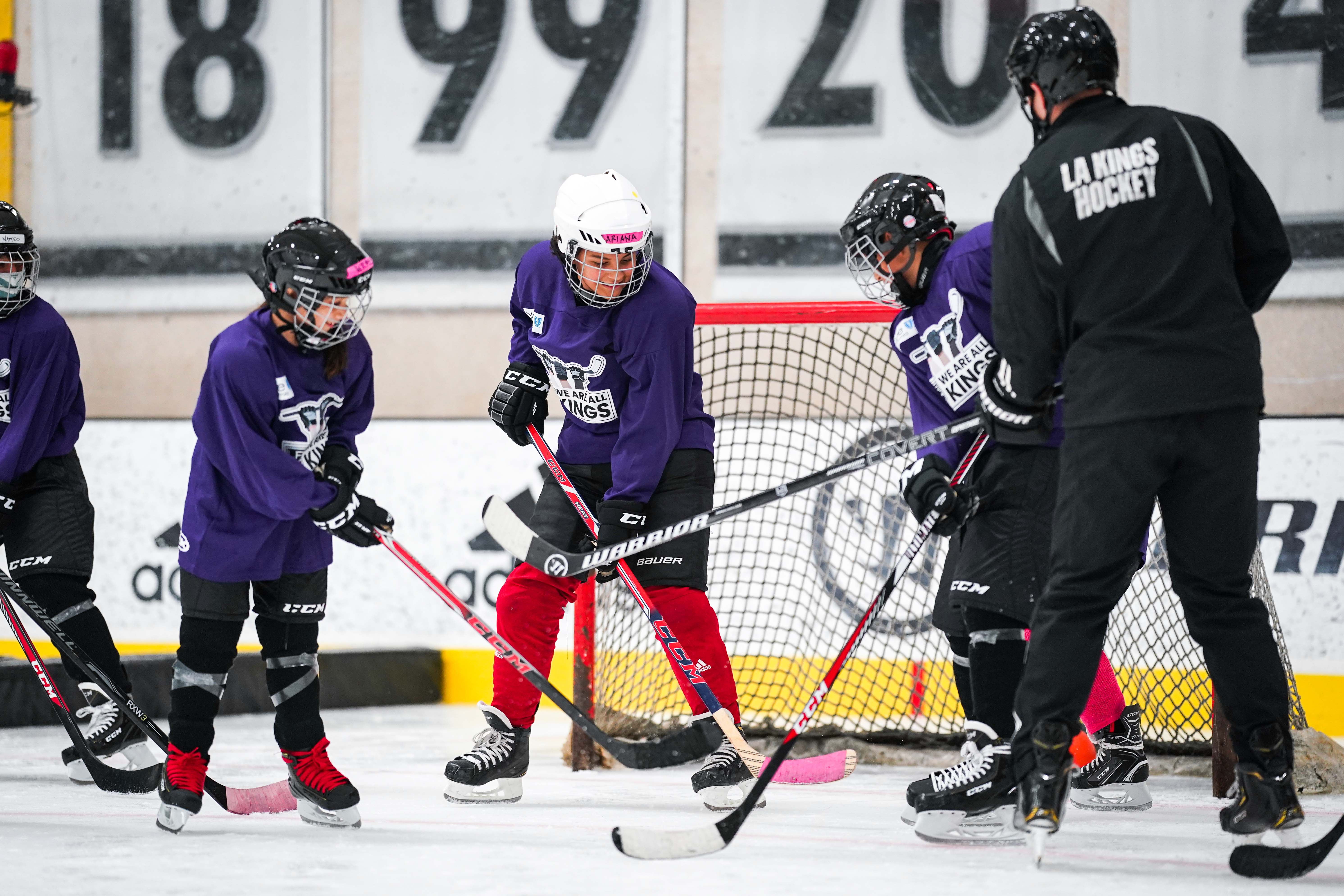 Youth camp participants play hockey on the ice rink at Toyota Sports Center.