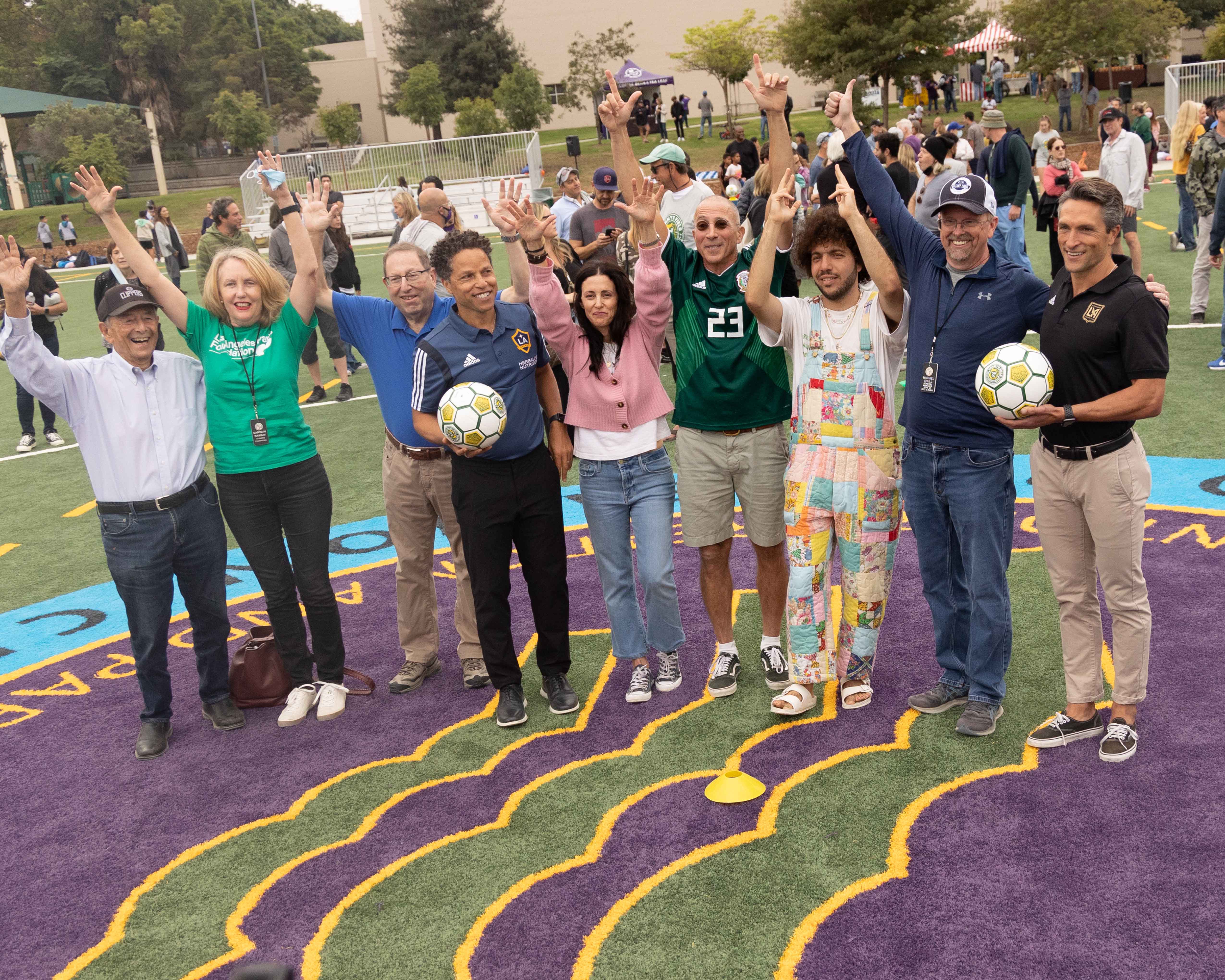 Members of the Mark family (center) are joined by representatives from the City of Los Angeles, LA Galaxy legend Cobi Jones (center left) and LAFC President John Thorrington (right) at center field of “Tommy’s Field” at Westwood Park Recreation Center in Los Angeles 