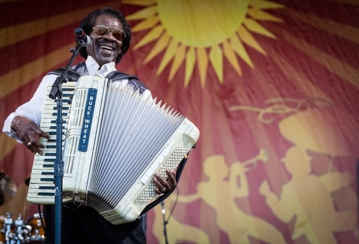 Image of a performer named Buckwheat on stage at New Orleans Jazz Fest playing the accordian
