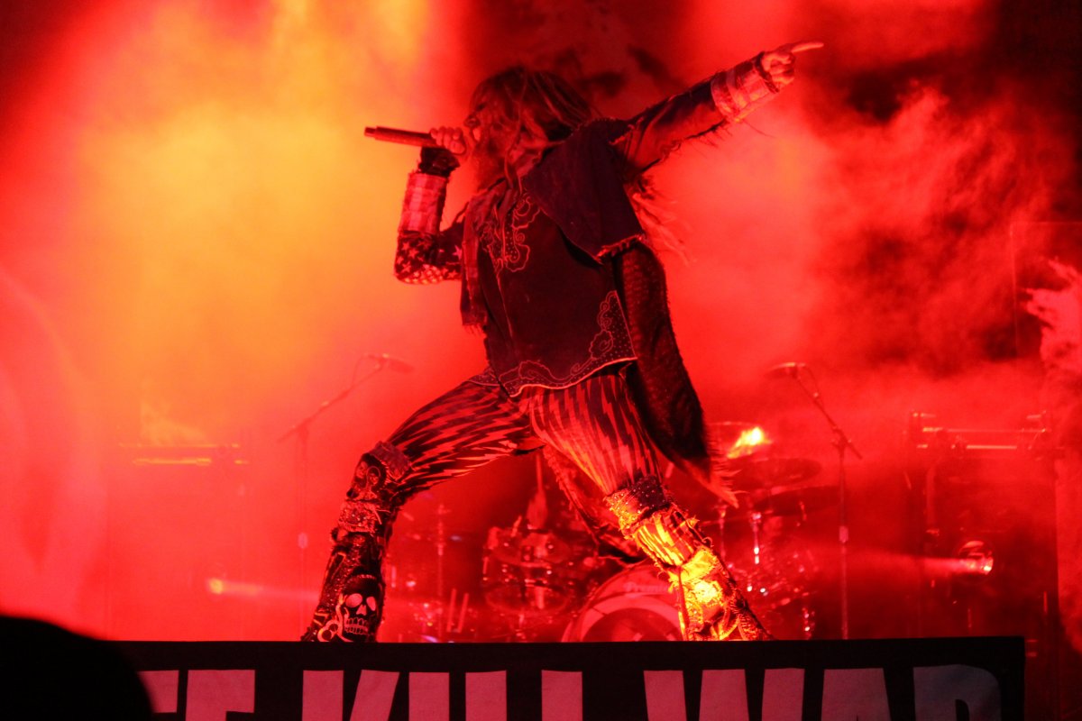 Image of performer on stage with red lighting and smoke
