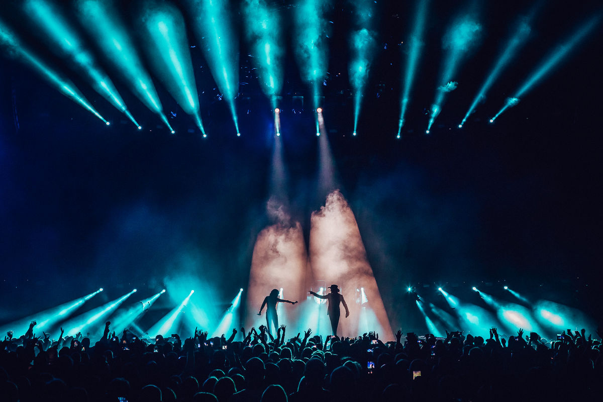 Silhouettes of two singers on stage