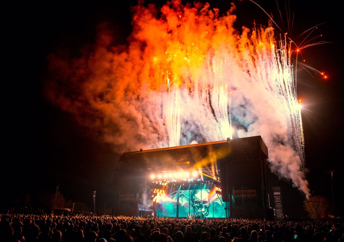 Image of stage at night with fireworks behind it
