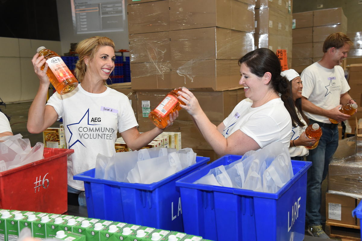AEG employee volunteers add apple juice to food kits on the assembly line at the Los Angeles Regional Food Bank in Commerce, Calif. on Aug. 29, 2017. Throughout the day AEG employees prepared more than 1,400 food kits to be distributed to seniors in the greater Los Angeles area.
