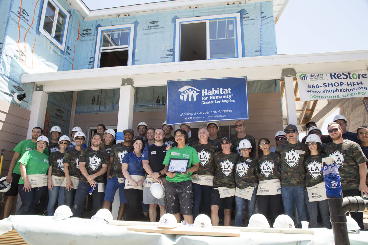 U.S. Navy veteran Tamara Lindsay (center) is presented with a full scholarship to Southern New Hampshire University (SNHU) on behalf of SNHU and AEG’s LA Galaxy at a Habitat for Humanity community build in Downey, Calif.