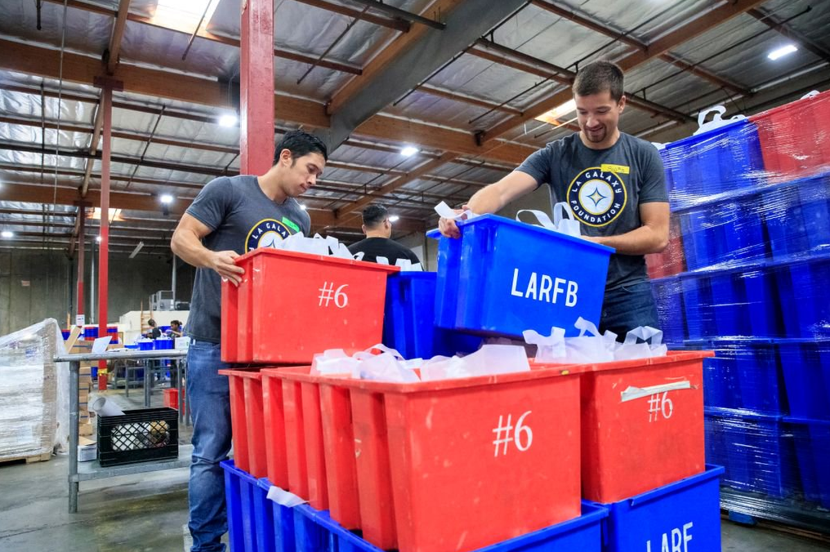 AEG’s LA Galaxy Staff stack crates of packaged meals to be distributed to children, families, seniors and individuals in need at the LA Regional Food Bank on October 13, 2017.