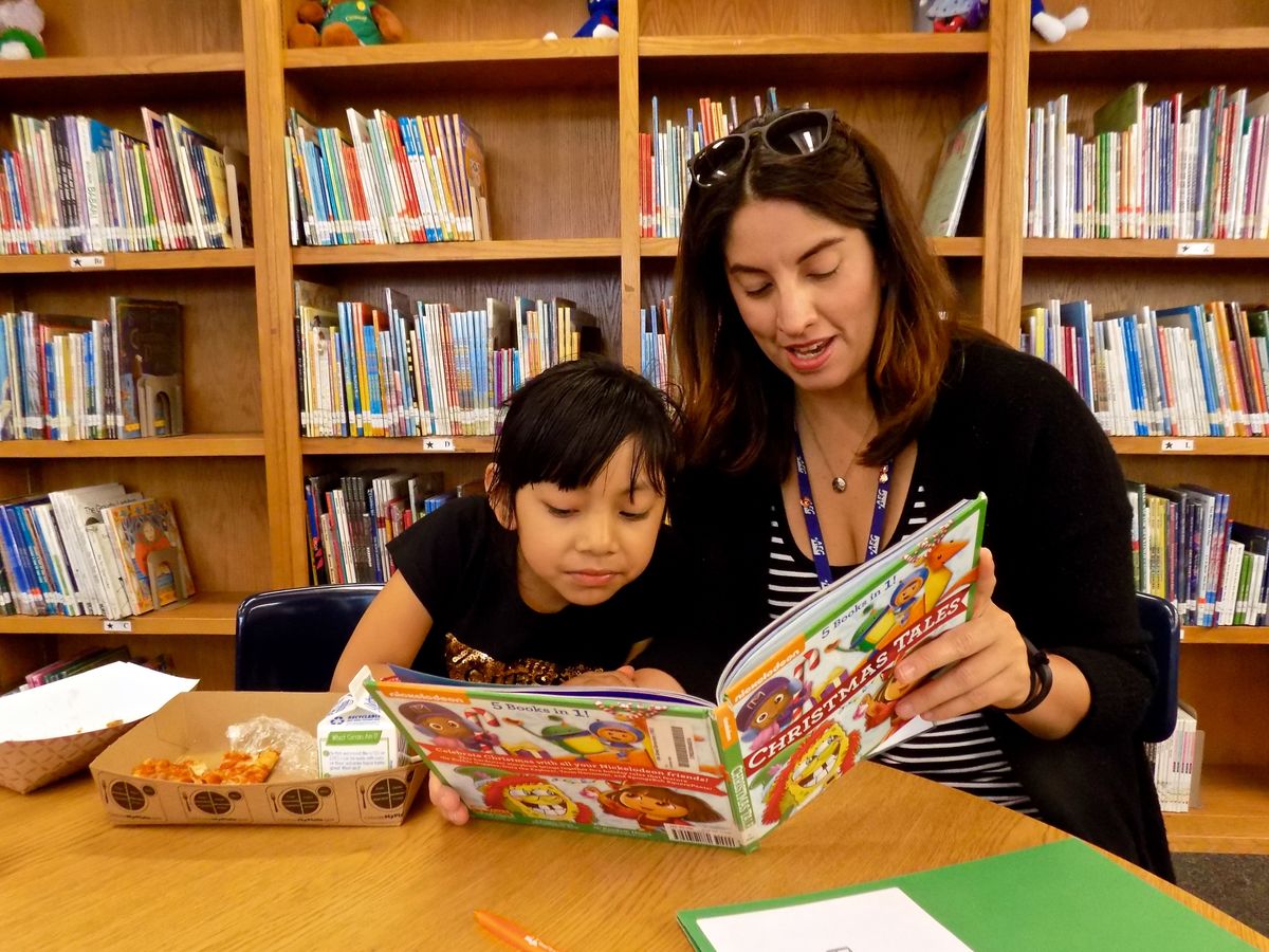 AEG’s Jatzin Alvarado reads to a student at Tenth Street Elementary in Pico-Union as part of the Read to a Child Lunchtime Program.