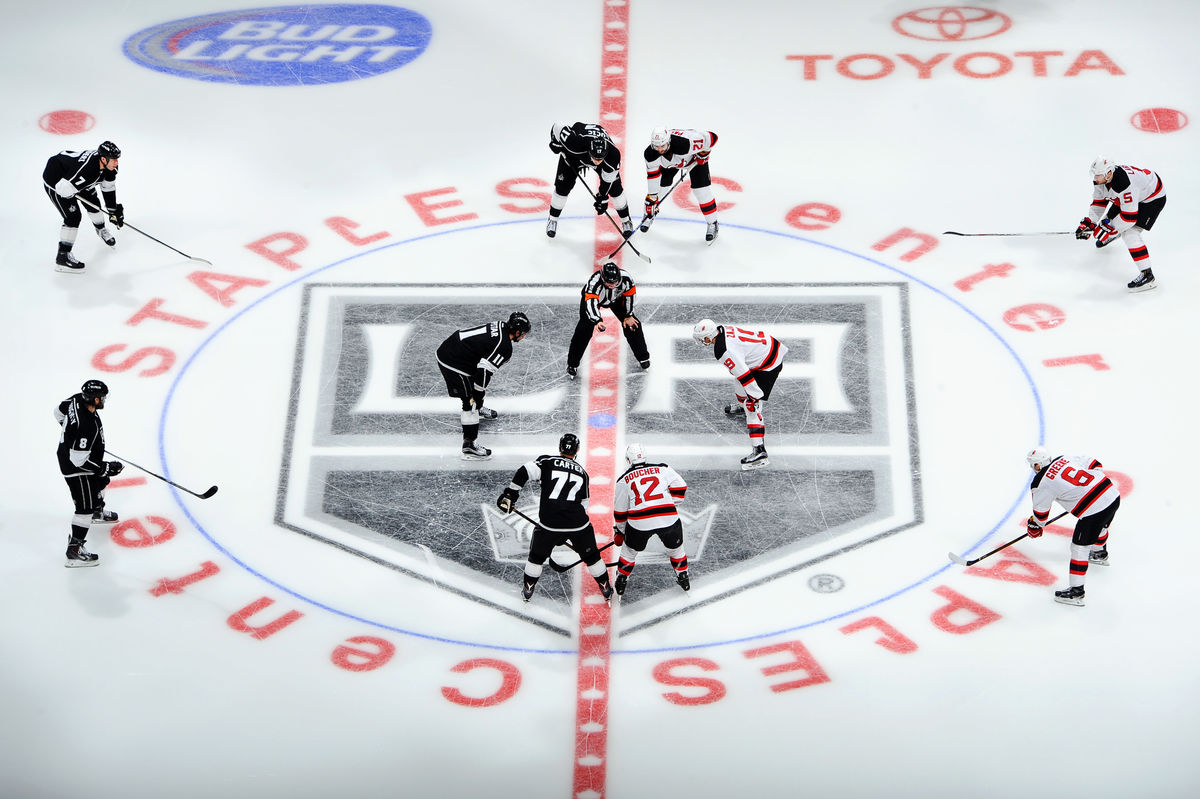 LA Kings players face off against an opposing team for the puck drop at STAPLES Center. 