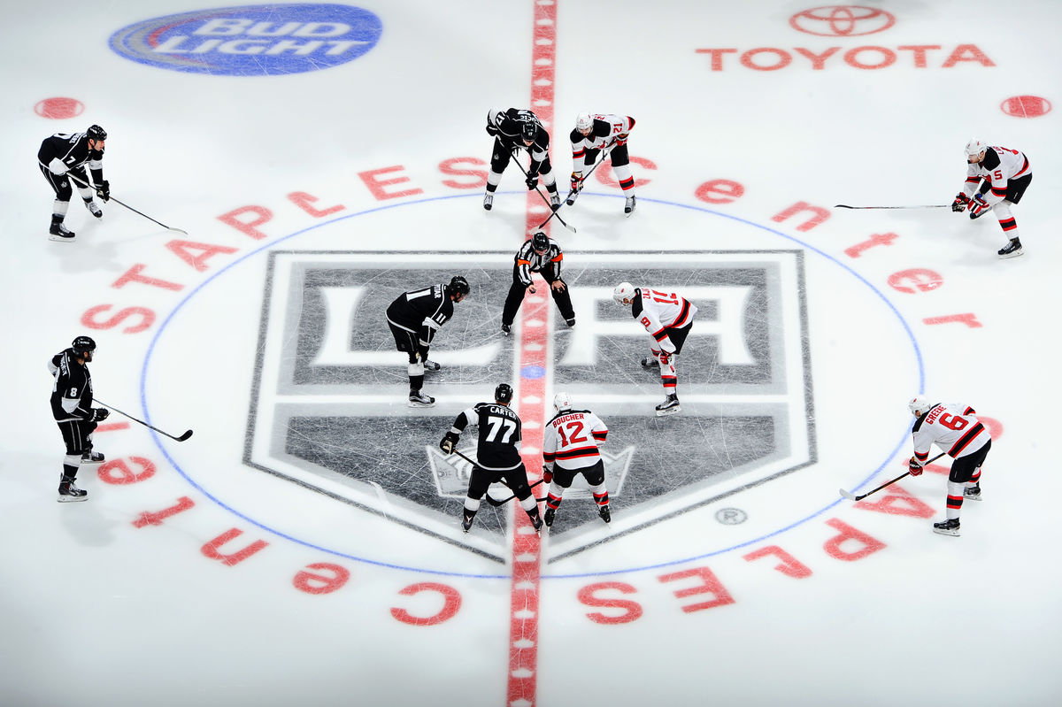 LA Kings players face off against an opposing team for the puck drop at STAPLES Center.