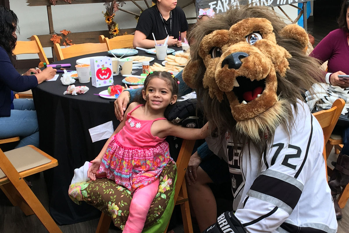 LA Kings mascot Bailey poses with a patient at the LA Kings Halloween party at the Los Angeles Ronald McDonald House on October 30, 2018.