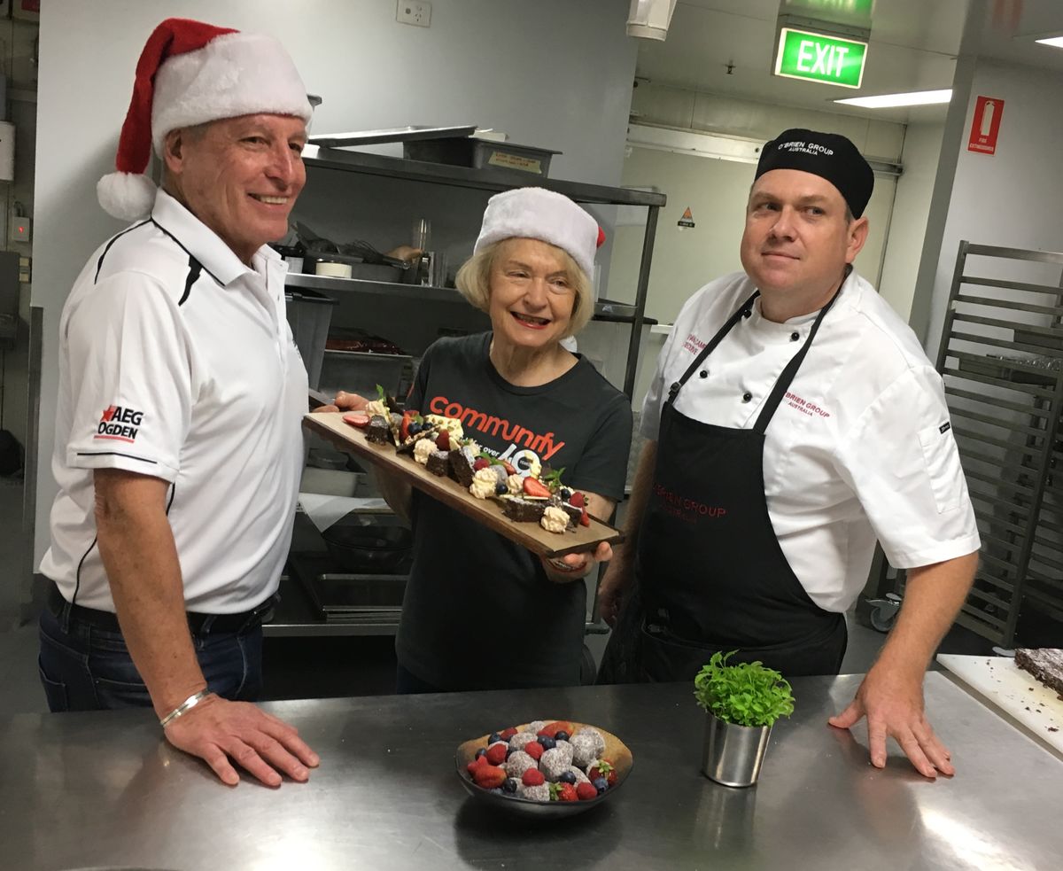 Suncorp Stadium General Manager Alan Graham (left), Communify Chair Carolyn Mason and O’Brien Group Australia Executive Chef, Bevan Campbell work in the stadium’s kitchen to finalize the menu for the Christmas Day lunch. 