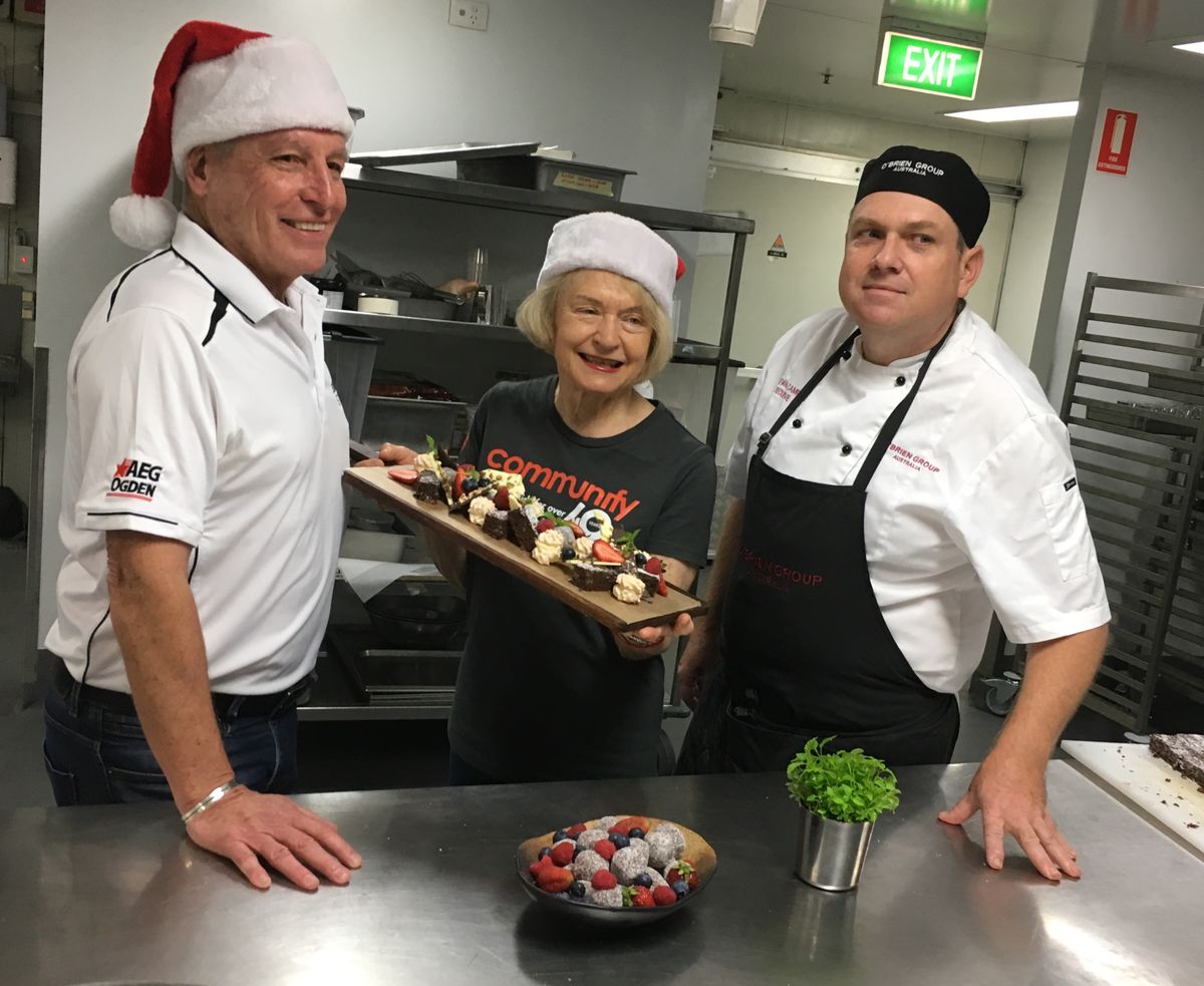 Suncorp Stadium General Manager Alan Graham (left), Communify Chair Carolyn Mason and O’Brien Group Australia Executive Chef, Bevan Campbell work in the stadium’s kitchen to finalize the menu for the Christmas Day lunch.