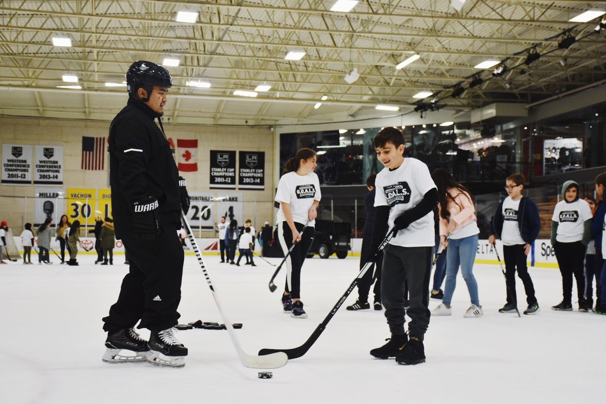 LA Kings staff teach students how to use angles to pass and shoot the hockey puck on the ice at Toyota Sports Center.