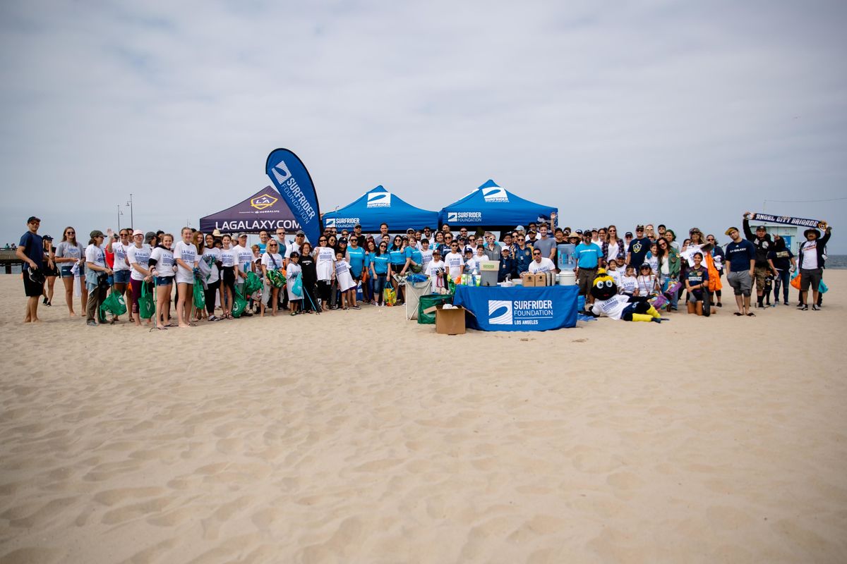More than 250 LA Galaxy fans gather at Venice Beach for a group photo following a beach cleanup.