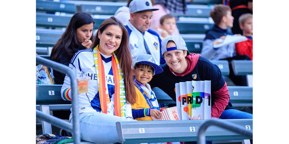 Fans smile for a photo in the stands of the LA Galaxy's Pride Night at Dignity Health Sports Park.
