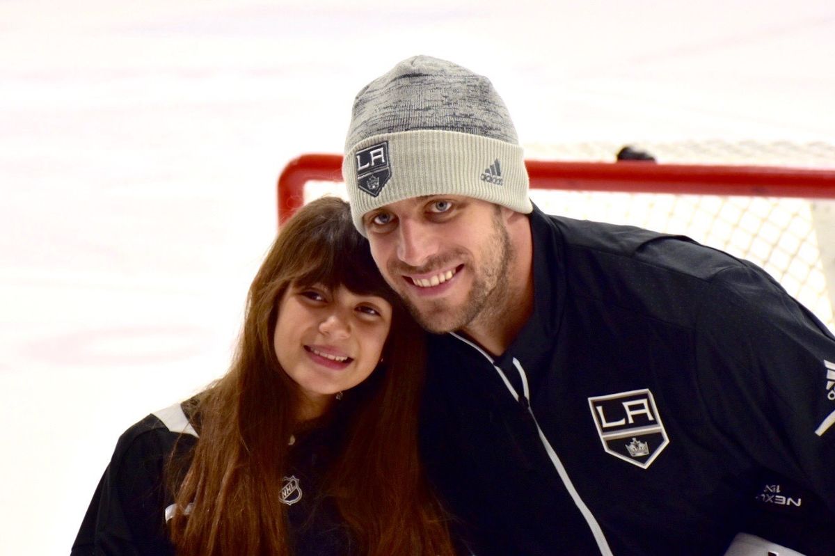 Christiann from Make-A-Wish Foundation poses for a photo with LA Kings Captain Anze Kopitar on the ice at Toyota Sports Performance Center. 