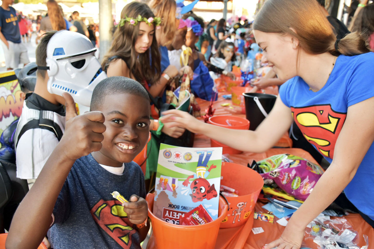 A little boy gives the camera a thumbs up between trick-or-treating on the concourse of Dignity Health Sports Park for their Halloween Bash.