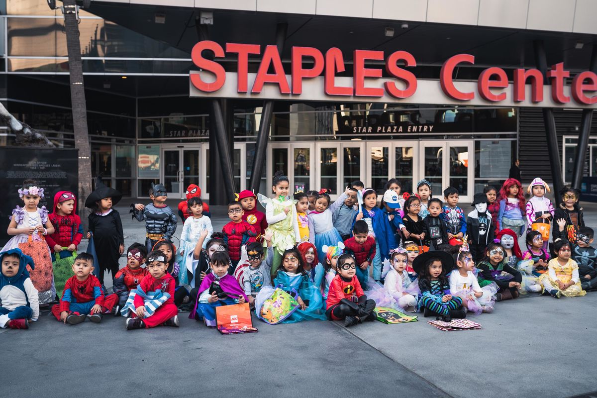 Children dress up in various Halloween costumes and pose for a group photo outside of STAPLES Center before trick-or-treating throughout AEG's offices on Halloween.