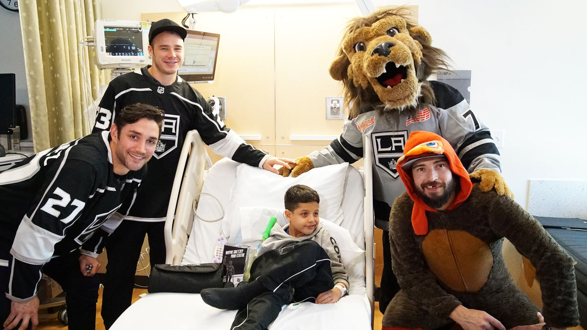 LA Kings Players Alec Martinez, Dustin Brown, Drew Doughty and LA Kings Mascot pose for a photo with a young male patient at Children's Hospital Los Angeles. 
