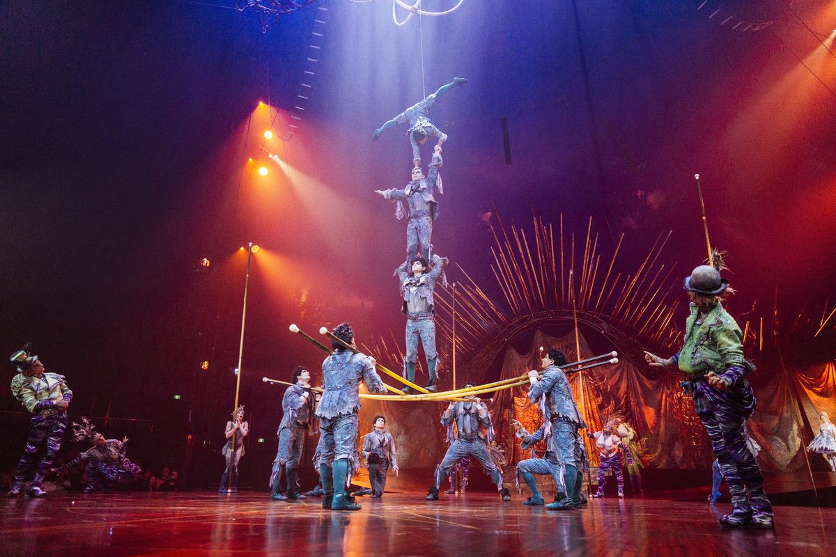 Cirque du Soleil acrobats stand upon each others shoulders during a performance.