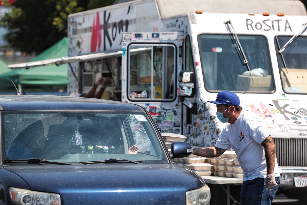 Chef Roy Choi hands meals out to residents of the Carson Community at Dignity Health Sports Park with the LA Galaxy.