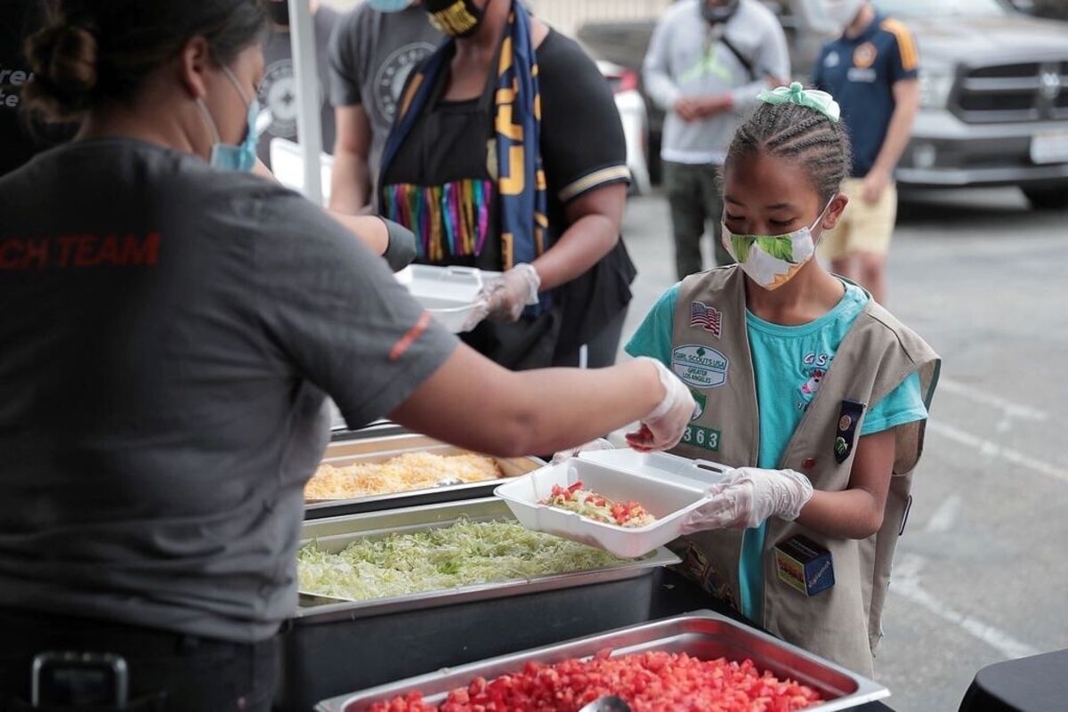 LA Galaxy volunteers work a taco assembly line to serve residents of Watts during COVID-19 relief efforts.