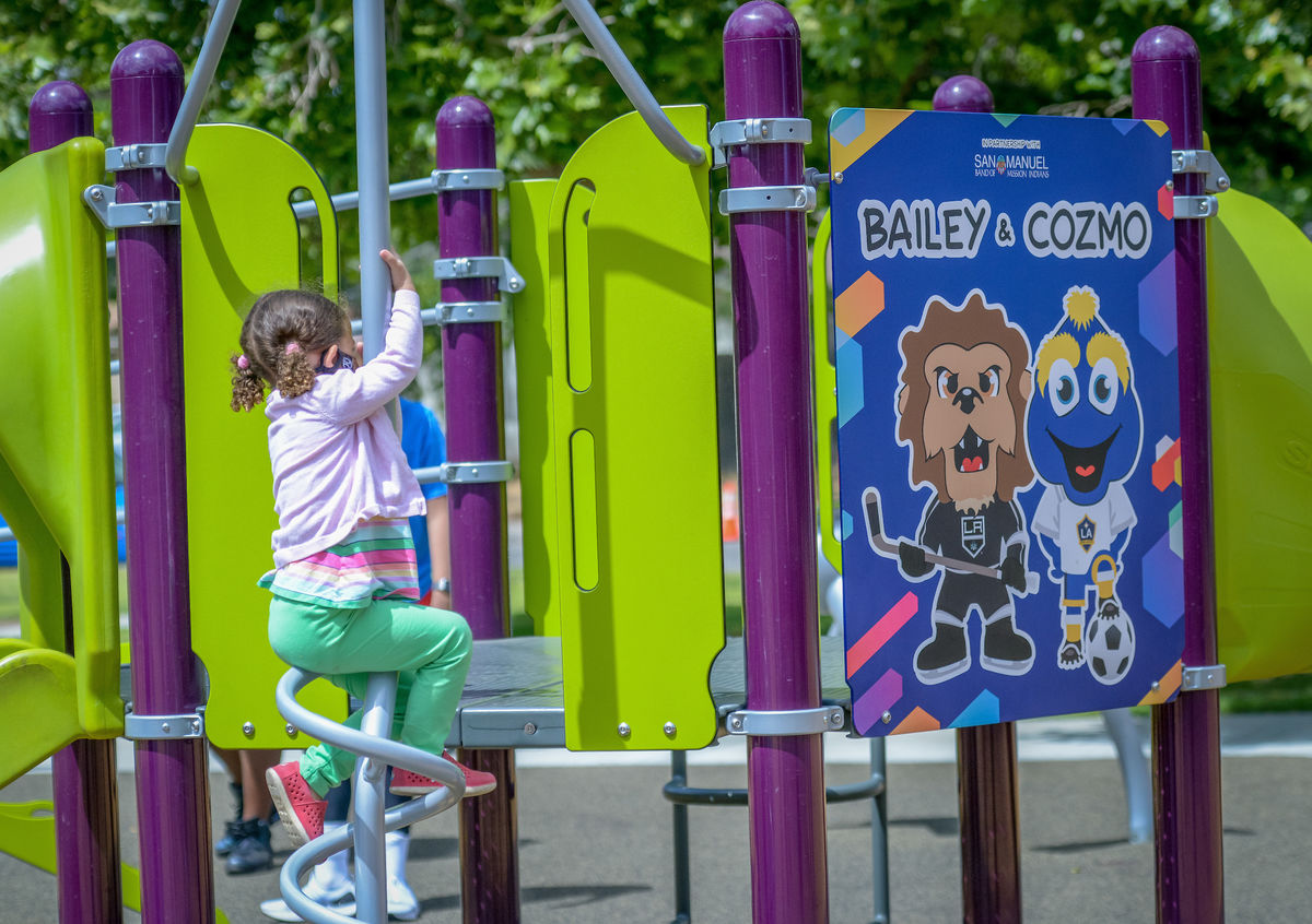 A little girl slides down a pole at a newly built playground by the LA Kings and LA Galaxy in San Bernardino, Calif.