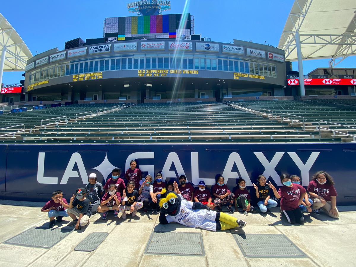 Students crowd around LA Galaxy mascot Cozmo for a group photo at Dignity Health Sports Park.