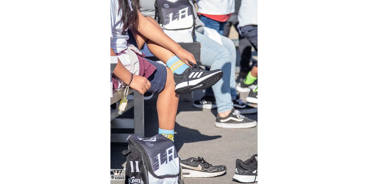A student tries on new adidas sneakers during the LA Kings Shoes That Fit event at an elementary school in Compton, Calif.