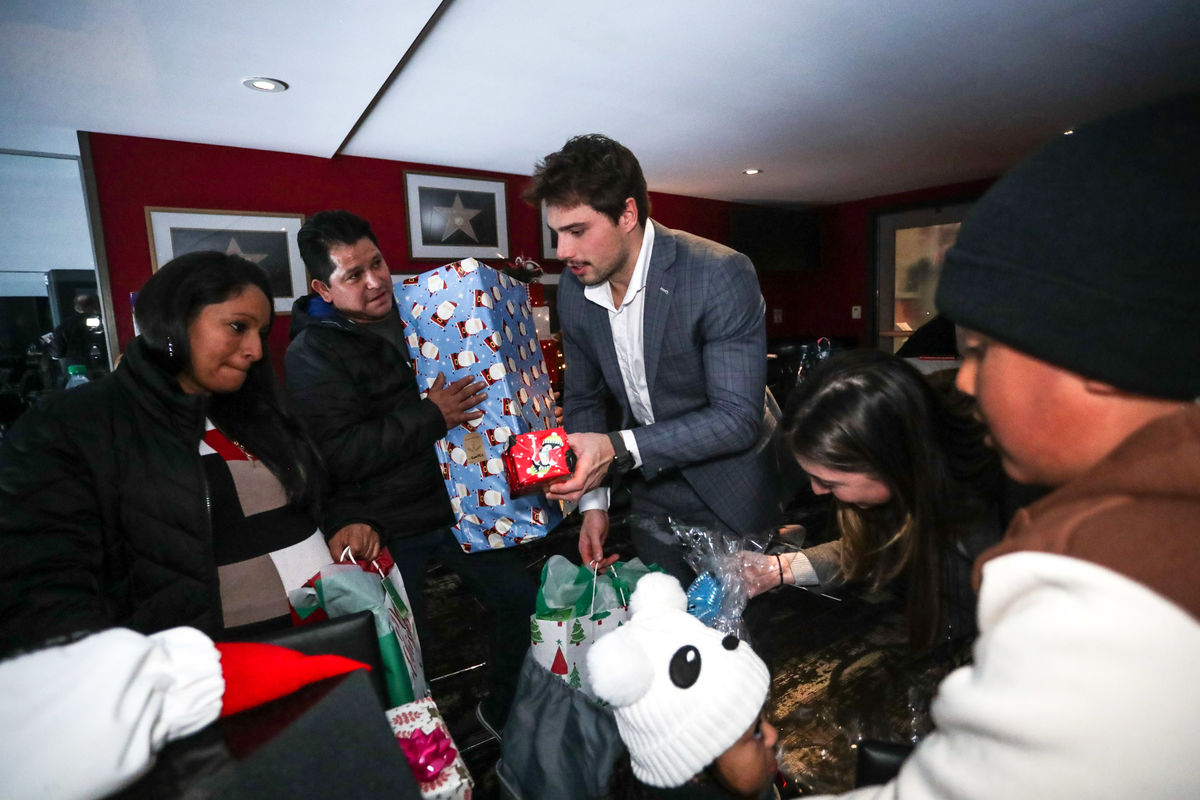 LA Kings players distribute gifts to families during the holidays.