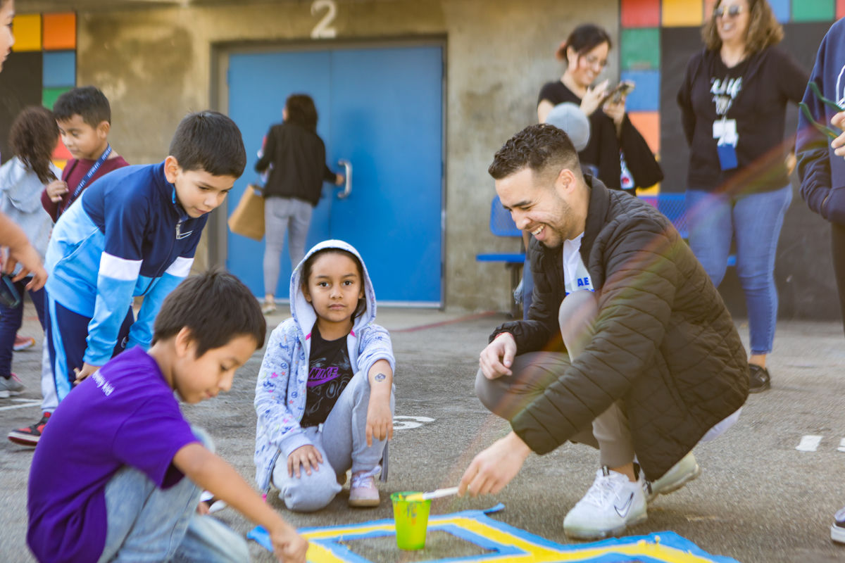 AEG volunteer plays with kids at annual Service Day