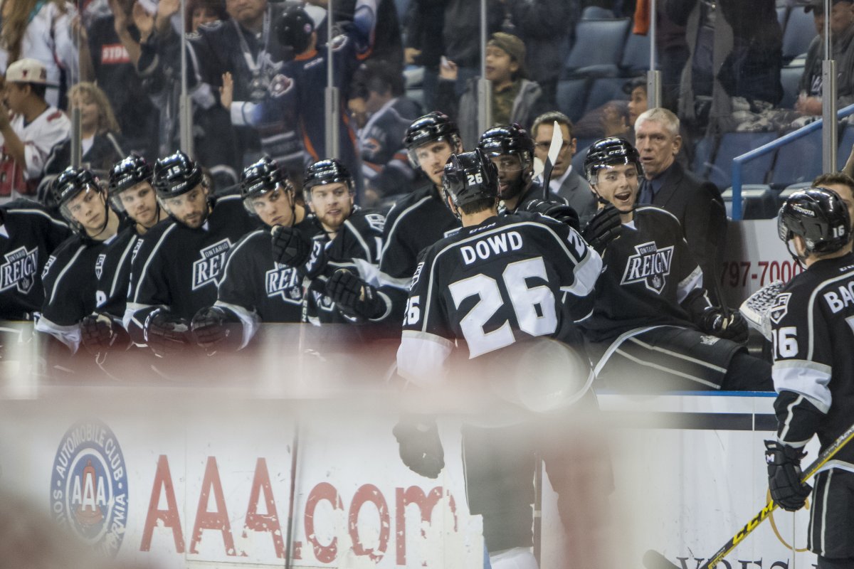 Reign players on the bench exchanging high fives with a player on the ice