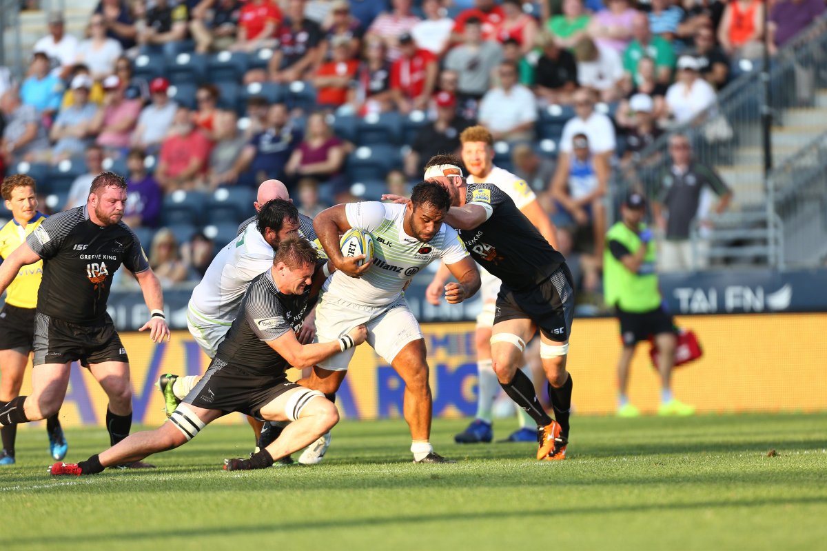Rugby players trying to tackle an opponent